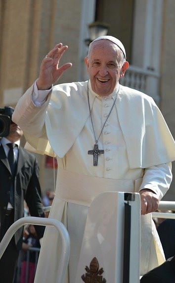 Pope Francis smiling and waving at an audience