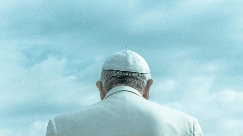 The back of Pope Francis' head, with a sky backdrop