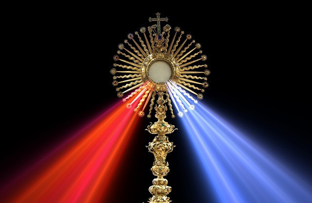 The Sacrament of the Eucharist with a red and blue light streaming from it